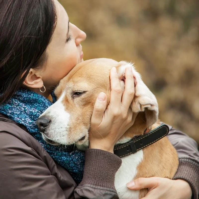 Lady hugging dog showing it love